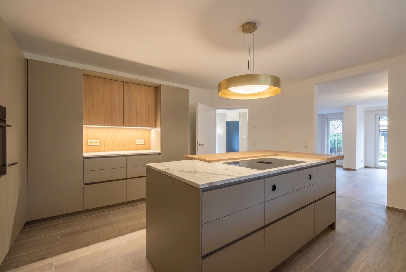 Warme Küche in Cashmere mit Kochinsel und Marmorplatte in einem umgebauten Wohnhaus